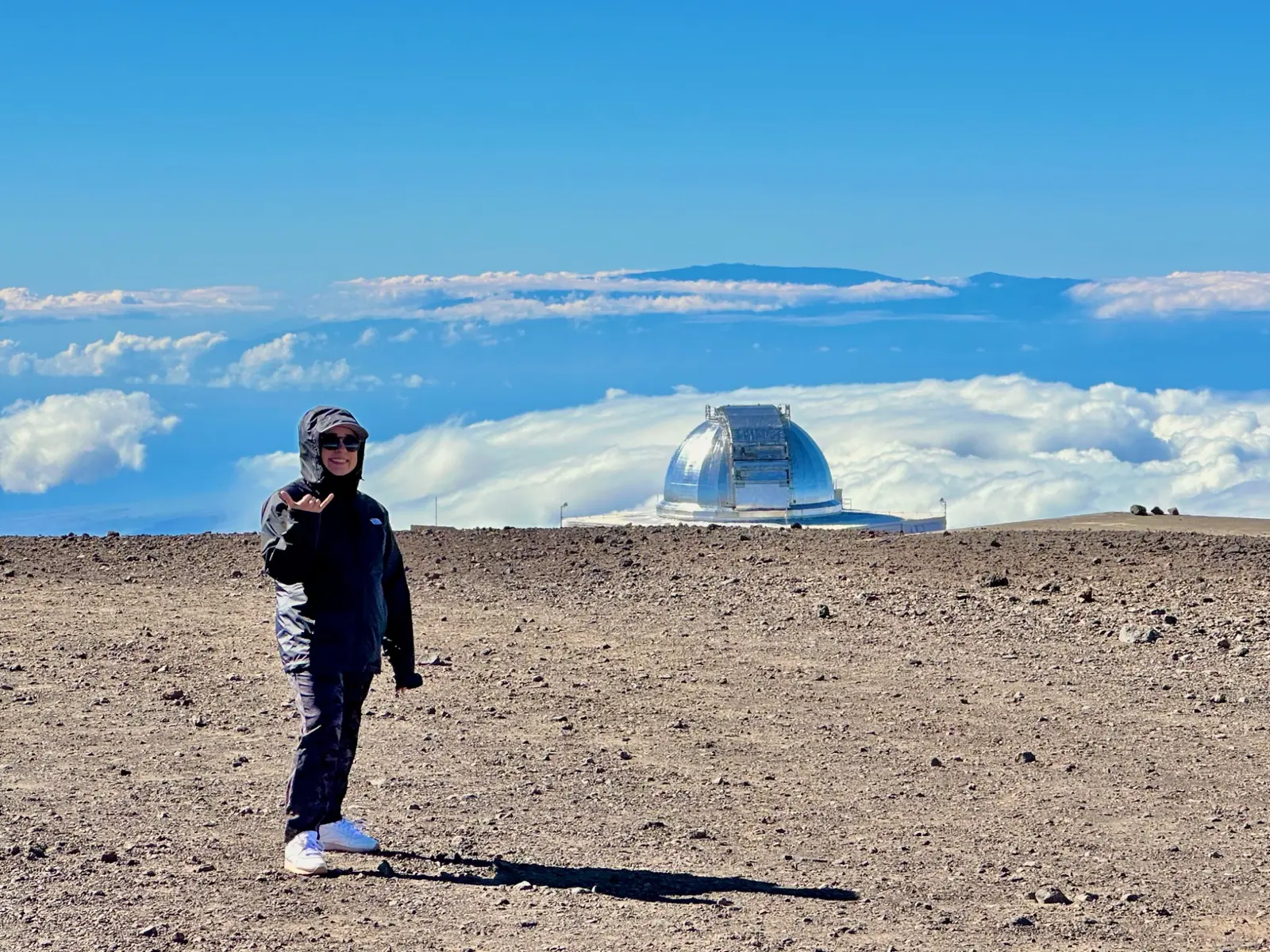 A wide view across Maunakea and its observatories beneath an open sky